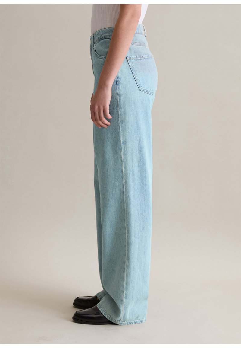 Helle blaue, weite Jeans mit hoher Taille, die Taschen aufweist und eine leicht verblasste Denim-Textur hat. Der Stoff wirkt weich und strapazierfähig.