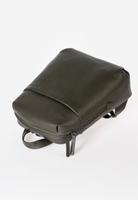 Groene leren rugzak met een gladde textuur, afgeronde bovenkant en ritssluiting. Voorzien van verstelbare schouders straps en dubbele ritshendels voor gemakkelijke toegang.