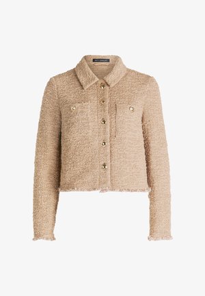 Beige kurze Jacke aus strukturiertem Stoff, mit Kragen, goldenen Knöpfen und zwei Fronttaschen. Die Säume sind ausgefranst.
