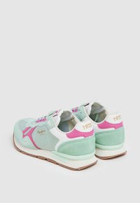 Scarpe sportive verde chiaro e rosa con materiali in rete e camoscio, caratterizzate da un design retro, dettagli bianchi e il numero "1973" in oro sul tallone.