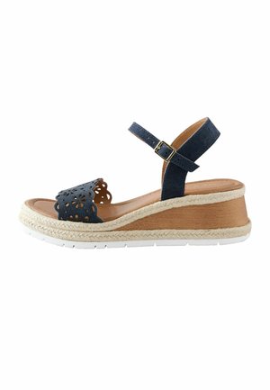 Marineblå kilehæl sandal med ankelrem, blomstret udskæringsdesign på tåremmen, fletdet jute-kant og hvid gummi-sål.