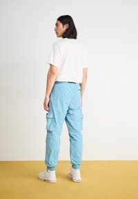 Nike Sportswear TECH WOVEN - Cargo trousers - denim turquoise/black