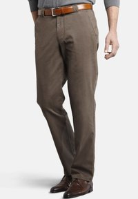 Braune Baumwollhosen mit geradem Schnitt, ausgestattet mit Seitentaschen und einer glatten Textur. Kombiniert mit einem braunen Leder-Gürtel und Schuhen.