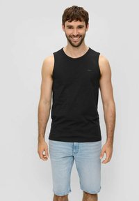 Schwarzes ärmelloses Tanktop mit rundem Ausschnitt, aus weichem Stoff, getragen zu hellblauen Jeansshorts. Einfaches Design mit minimaler Markenkennzeichnung.
