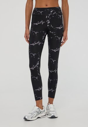 Leggings neri con un motivo a marmo in diverse tonalità di grigio. Realizzati in materiale elastico, presentano una vita alta e una texture liscia.