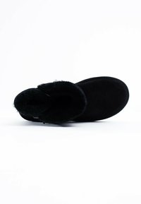 Stivale alla caviglia in suede nero con una morbida fodera in pelliccia, punta arrotondata e suola piatta. Presenta un design semplice e pulito, privo di decorazioni.
