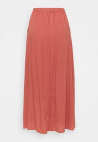 Jupe maxi d'une couleur corail chaude, fabriquée en tissu doux. Elle dispose d'une taille élastique et de deux poches latérales pour un confort supplémentaire.