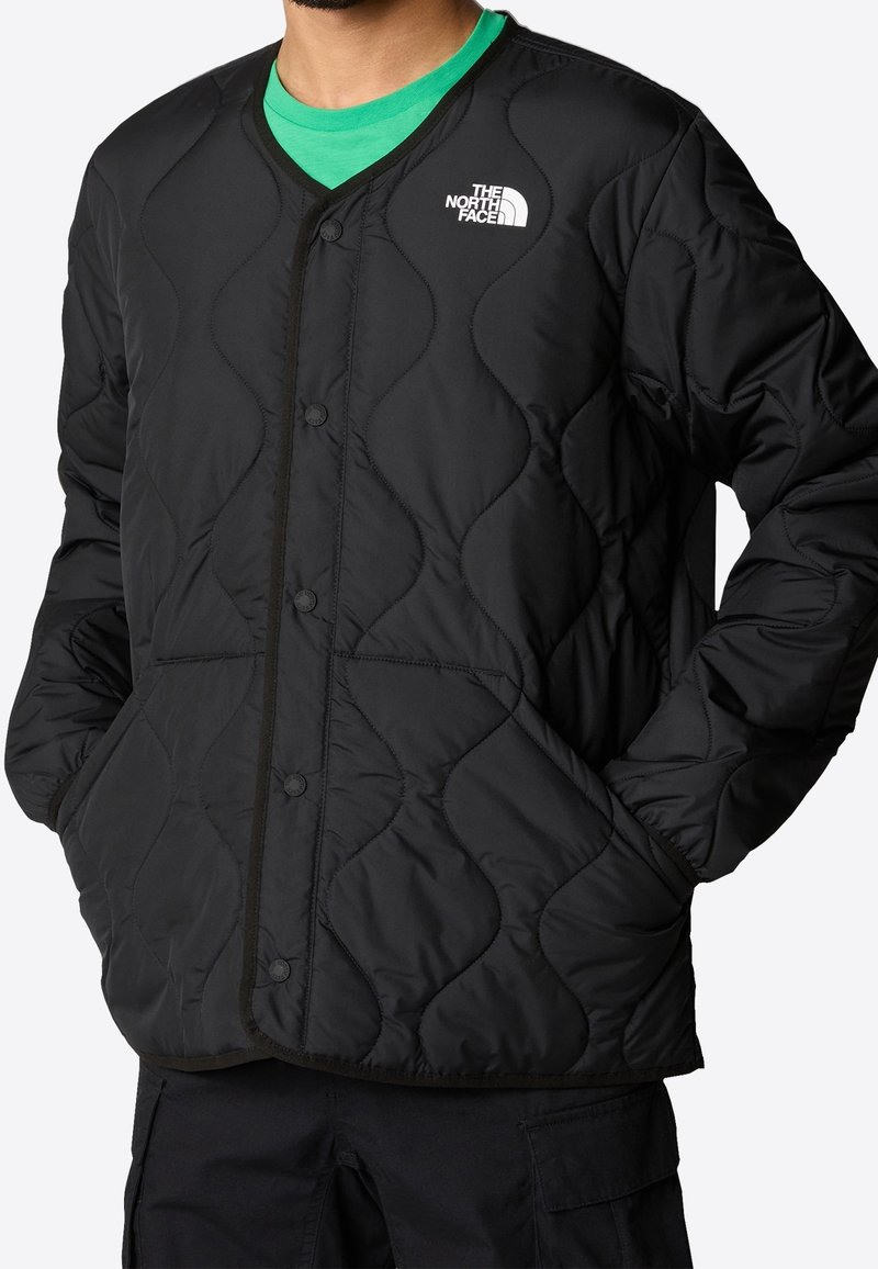 Czarna pikowana kurtka z dekoltem w serek, zapięciem na napy, bocznymi kieszeniami i logo The North Face na lewej piersi.