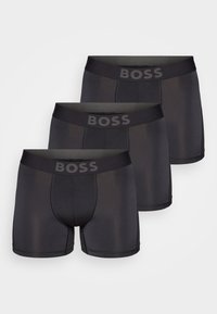 Three pairs of black boxer briefs in a fitted design, featuring a thick waistband with "BOSS" logo and smooth fabric for comfort and flexibility.