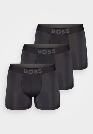 Drei Paar schwarze boxer Shorts in enganlier Passform, mit einem breiten Bund und dem "BOSS"-Logo sowie einem glatten Stoff für Komfort und Flexibilität.
