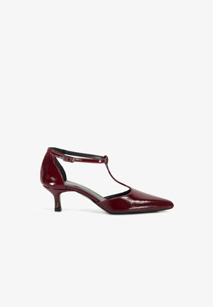 Bordeaux lakleren T-strap pump met een puntige neus, lage hak en verstelbare enkelband, met een gladde textuur en een gestroomlijnd ontwerp.