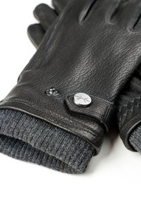 Sorte læderhandsker med en tekstureret overflade, grå strikket manchet og metal trykknapdetalje, der viser et strømlinet design og solidt håndværk.