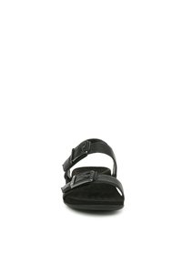 Sandales noires avec deux sangles réglables et boucles, semelle intérieure texturée et semelle plate, conçues pour le confort et la stabilité.