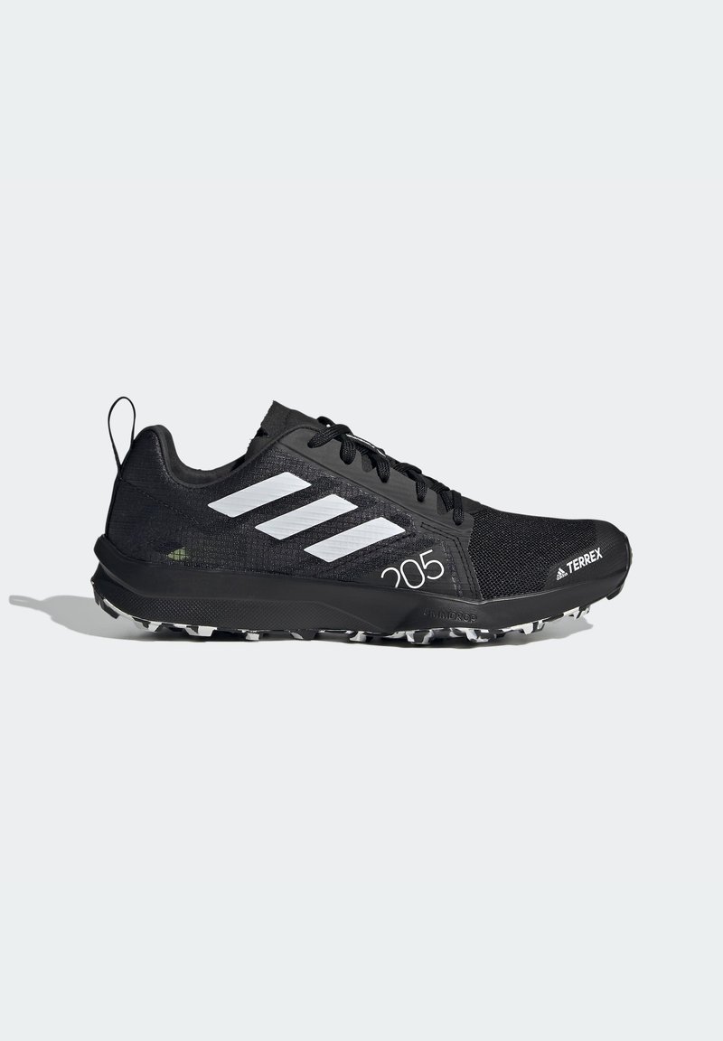 Scarpa da corsa nera con parte superiore in mesh testurizzato, design a tre stripe bianche e suola in gomma nera con tacchetti per la trazione. Presenta una linguetta per facilitare la calzata.