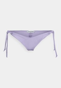 Parte de baixo de biquíni lavanda com laços laterais ajustáveis, apresentando uma textura suave e um design minimalista. O rótulo no interior mostra informações da marca.