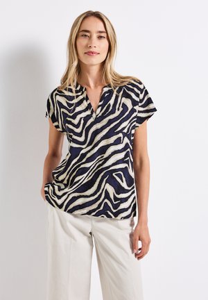 Short-sleeve blouse in navy and cream with an abstract zebra stripe pattern, featuring a v-neck and a loose-fitting design.