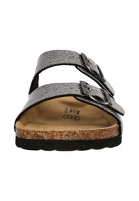 Tvåremmade sandaler med en glittrig silverfärgad syntetövre, svarta justerbara spännen och en korkfotbädd. Svart gummisula.