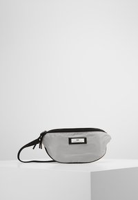 Szary nylonowy worek z czarnym zamkiem błyskawicznym i paskiem. Posiada prostokątną etykietę z napisem "DAY" w czarnym kolorze. Zaokrąglony kształt i gładka tekstura.