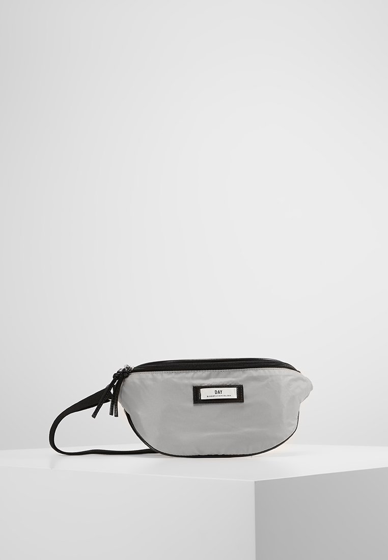 Szary nylonowy worek z czarnym zamkiem błyskawicznym i paskiem. Posiada prostokątną etykietę z napisem "DAY" w czarnym kolorze. Zaokrąglony kształt i gładka tekstura.