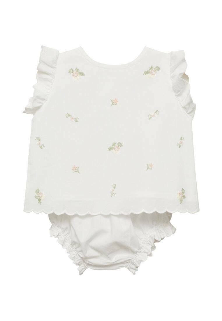 Vit ärmlös topp med volanger på axlarna, prydd med blommig broderi i pastellfärger. Inkluderar matchande vita volangbyxor.