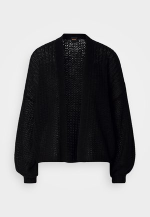 Sort, åben-frem cardigan lavet af strikstof. Har løse ærmer og et tekstureret mønster. Ingen lukning med en afslappet silhuet.