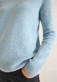Hellblaues, geripptes Strickpullover mit langen Ärmeln und lockerer Passform. Verfügt über eine subtile Textur und einen rund geschnittenen Halsausschnitt.