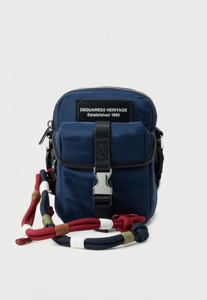 Kleine marineblauwe crossbodytas met voorste gesp, ritssluiting, zwart etiket met de tekst "DSQUARED2 HERITAGE Established 1995" en een meerkleurige touwriem.
