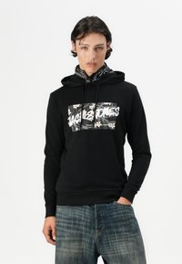 Fekete kapucnis pulcsi virágos mintával és "JACK & JONES" felirattal. Texturált anyagú, elülső zsebbel és húzózsinóras kapucnival.