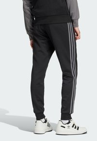 adidas Originals Spodnji deli trenirk - black   grey four