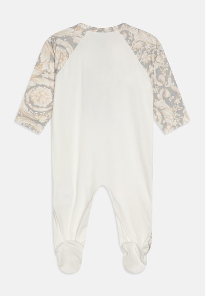 Ilga piedurkņu kombinezons krēmkrāsā ar pelēku ziedu rakstu augšējo daļu. Iezīmējas ar kājām un apaļu apkakli ar kontrastējošām piedurknēm. Mīksta auduma.