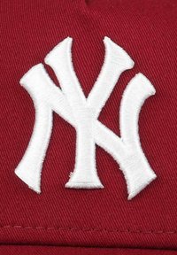Rote Baseballmütze mit einem auffälligen weißen bestickten "NY"-Logo auf der Vorderseite, mit einer strukturierten Stoffoberfläche und geformtem Design.