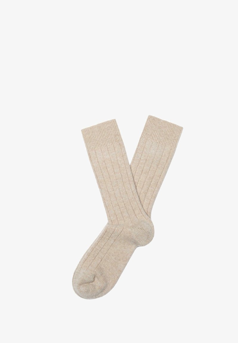 Beige Baumwollsocken mit vertikal gerippter Struktur, verstärkter Ferse und Spitze sowie elastischen Bündchen für einen sicheren Sitz.