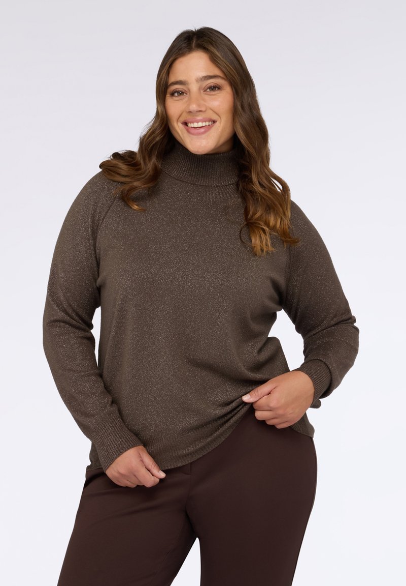 Maglione dolcevita marrone con una leggera brillantezza, maniche lunghe e vestibilità rilassata, abbinato a pantaloni marrone scuro. Tessuto lavorato a maglia morbido e testurizzato.