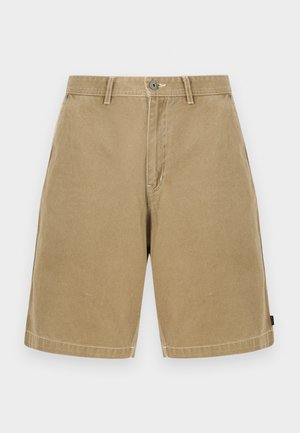 Beige Herren-Baumwollshorts in knielanger Länge mit Knopf- und Reißverschluss, Gürtelschlaufen und Seitentaschen vor einfarbigem Hintergrund.