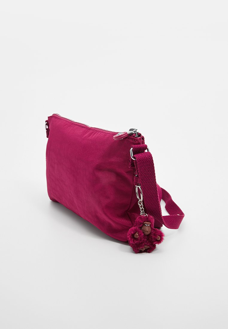 Borsa a tracolla fucsia realizzata in tessuto strutturato, con chiusura con zip e un portachiavi in peluche rimovibile. Tracolla regolabile per comodità.