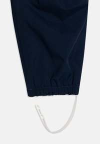 Marineblå stoff med en jevn tekstur, med elastisk midjebånd og en hvit snor for justerbar passform.