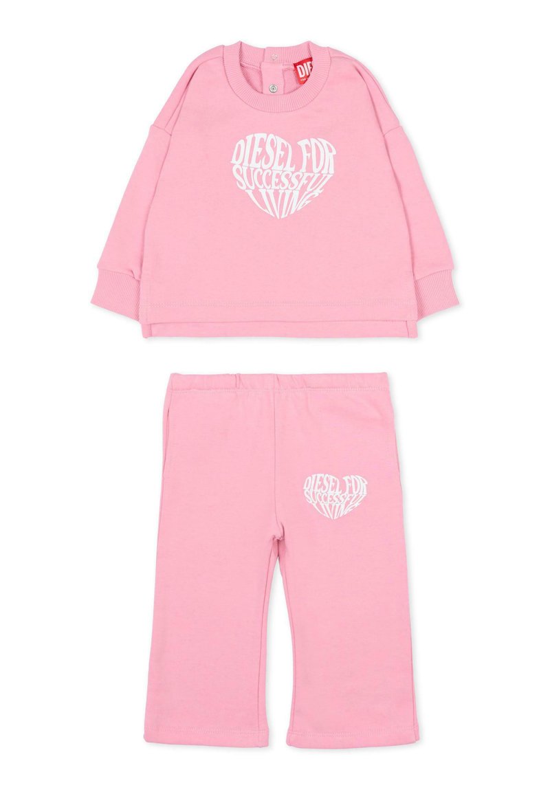 Różowy bawełniany dres z bluzą z długim rękawem ozdobioną białym tekstem w kształcie serca oraz pasujące spodnie z elastycznym stanem.