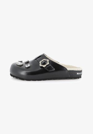 Zoccoli neri slip-on realizzati in materiale lucido, con gemme decorative e un accentuato fiore in metallo sulla fascia, dotati di un morbido rivestimento interno.