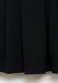 Schwarzer plissierter Rock aus weichem, strukturiertem Stoff. Hat ein einfaches, klares Design mit einem elastischen Bund und ohne sichtbare Verzierungen.