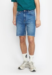 Leren denim shorts in lichtblauw met een klassieke snit, voorzien van vijf zakken, een knoopsluiting en lichte slijtplekken langs de zoom.