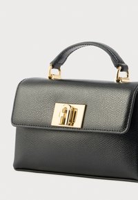 Mustast nahast käekott tekstuurse pinnaga, kuldsed detailid, ülemine käepide ja ristküliku kujuline, millel on kinnituslukk.