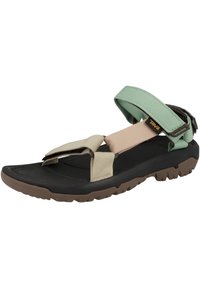 Black and brown flat sandal featuring wide webbed straps in green, pink, and beige. Textured rubber sole for traction. Adjustable closure.