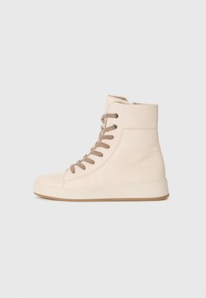 Sneaker alta in pelle crema con lacci beige, suola testurizzata e cuciture minimaliste su uno sfondo bianco semplice.
