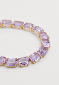 Purple rectangular stones set in gold-toned metal, forming a circular bracelet. Each stone features facets that reflect light.