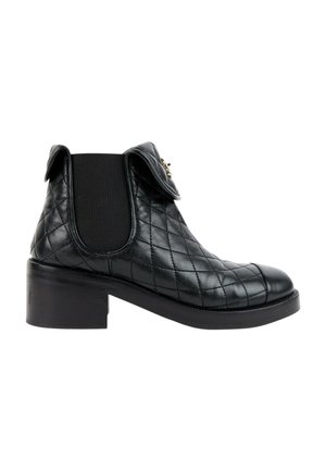 Bottine en cuir noir avec motif matelassé, panneau latéral élastique, petit talon bloc et petit détail de rabat plié près du haut.