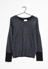 Maglione lungo grigio scuro a maniche lunghe con polsini neri appeso a una gruccia nera su uno sfondo bianco.