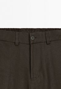 Dark brown pants waist with elastic back, belt loops, button closure, and a hidden zipper.