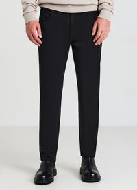 Schwarze Hose mit schlanker Passform, aus einem glatten Stoff gefertigt. Bietet Fronttaschen und einen Reißverschluss mit einem metallischen Knopf zum Schließen.