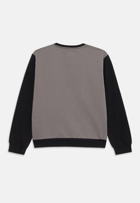 Felpa grigia con maniche nere, polsini e bordo a coste, texture liscia, design semplice, etichetta sul retro, stile girocollo.