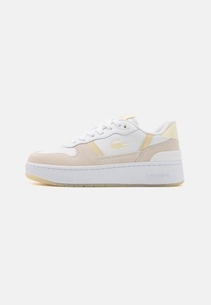 Białe i beżowe niskie sneakersy z grubą podeszwą, wiązane z przodu, z logo krokodyla Lacoste po boku i na podeszwie.